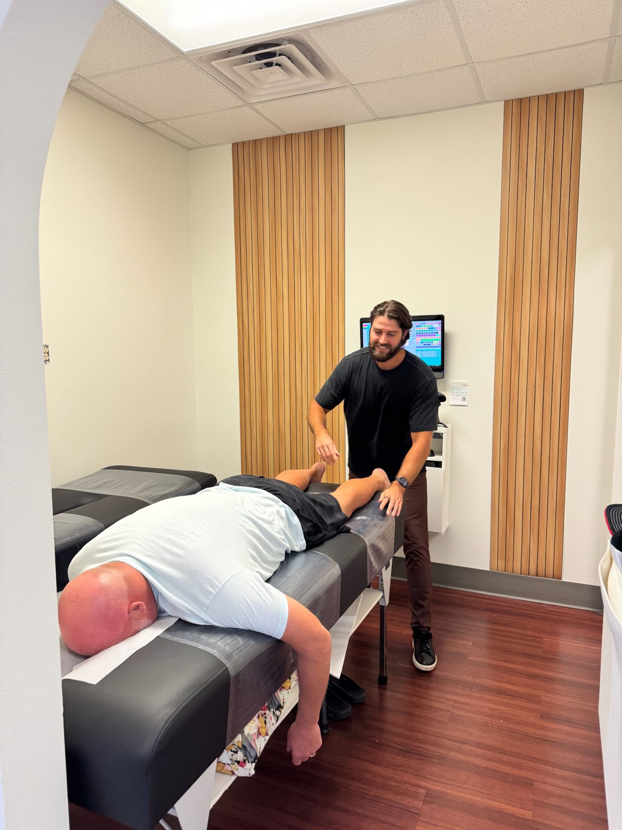 Dr. Logan Swaim adjusting an adult patient at The Roots Health Centers in Lakewood Ranch, FL.