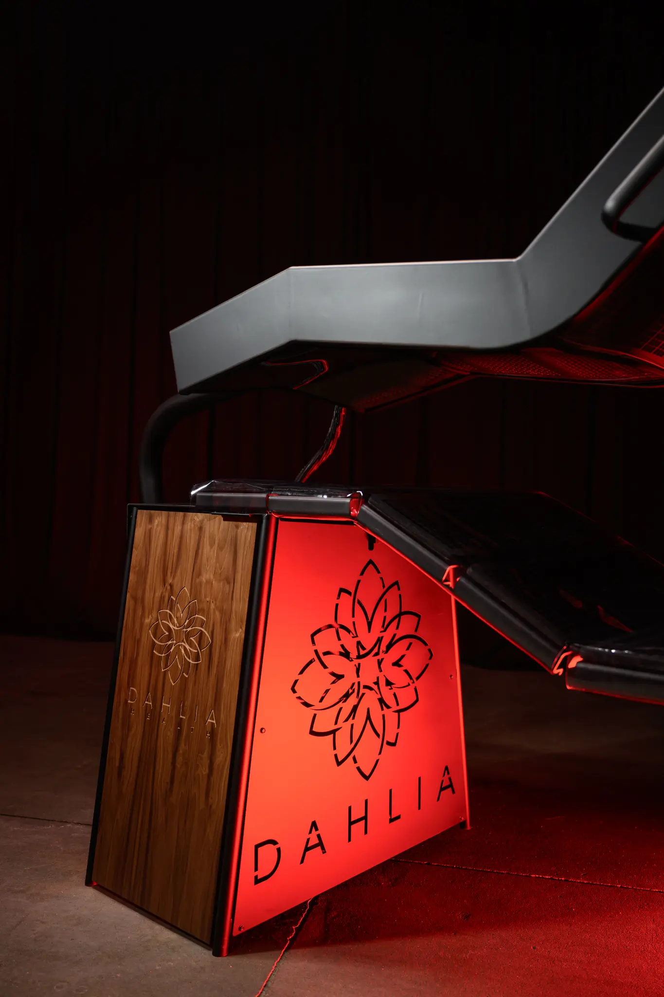 Close-up of the DAHLIA wooden base with the signature lotus brand mark.