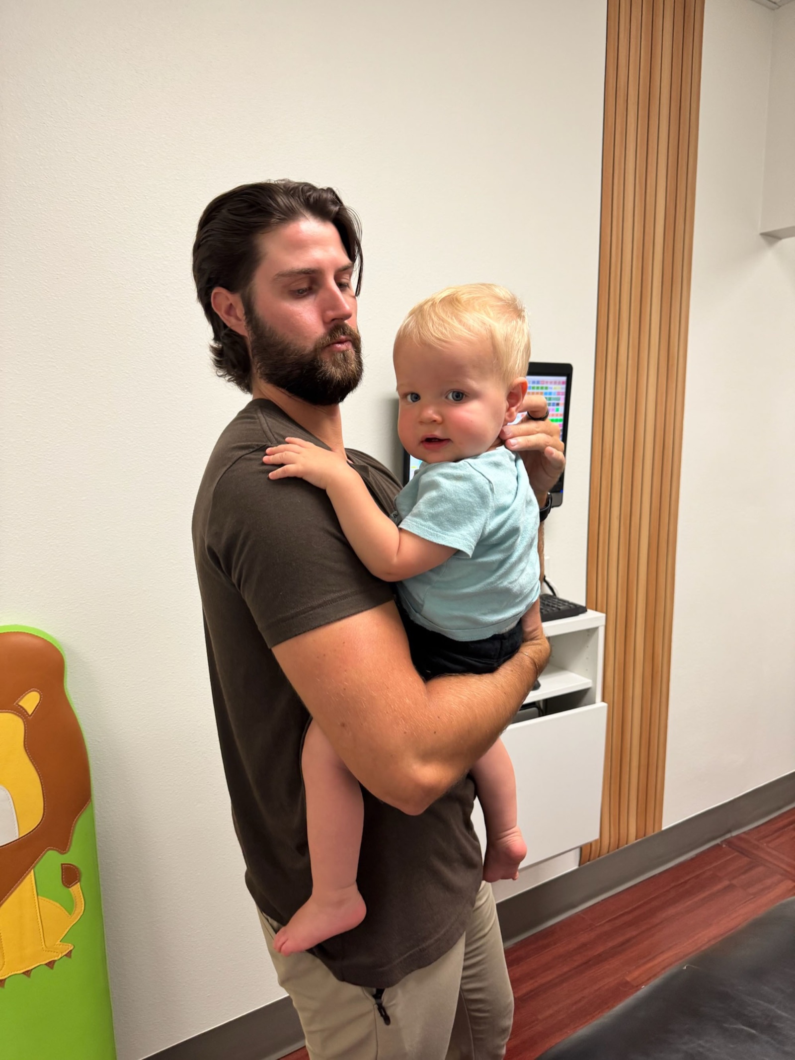 Dr. Fox holds a curious baby in the clinic hallway.