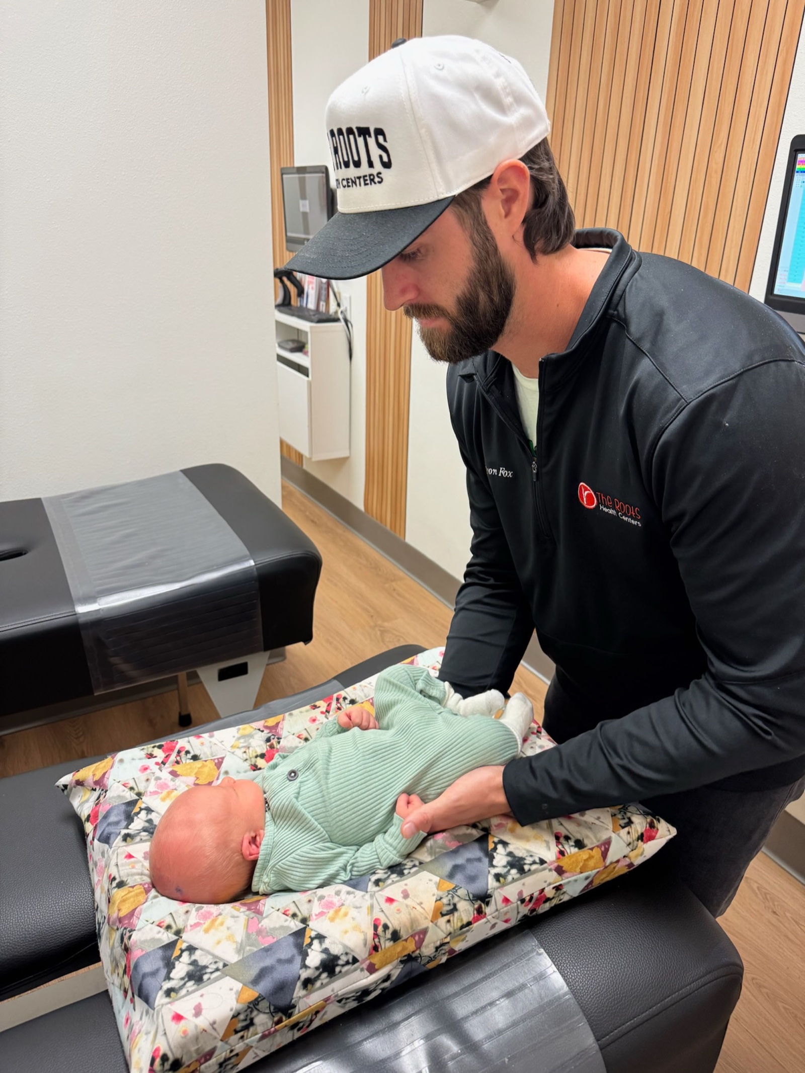 Dr. Fox gently adjusts a newborn on a pediatric pillow.