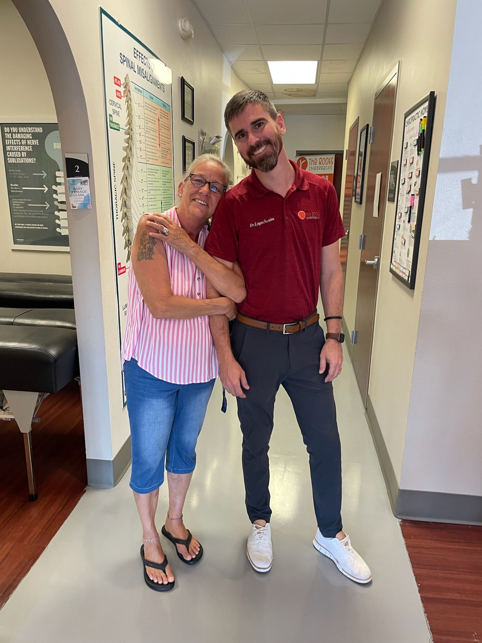 Dr. Logan Swaim smiles with a longtime patient in the clinic hallway.
