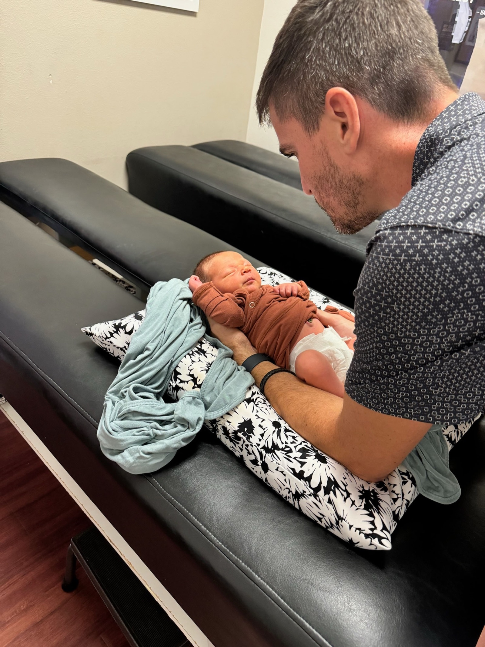 Dr. Logan Swaim holds his toddler son in the clinic.