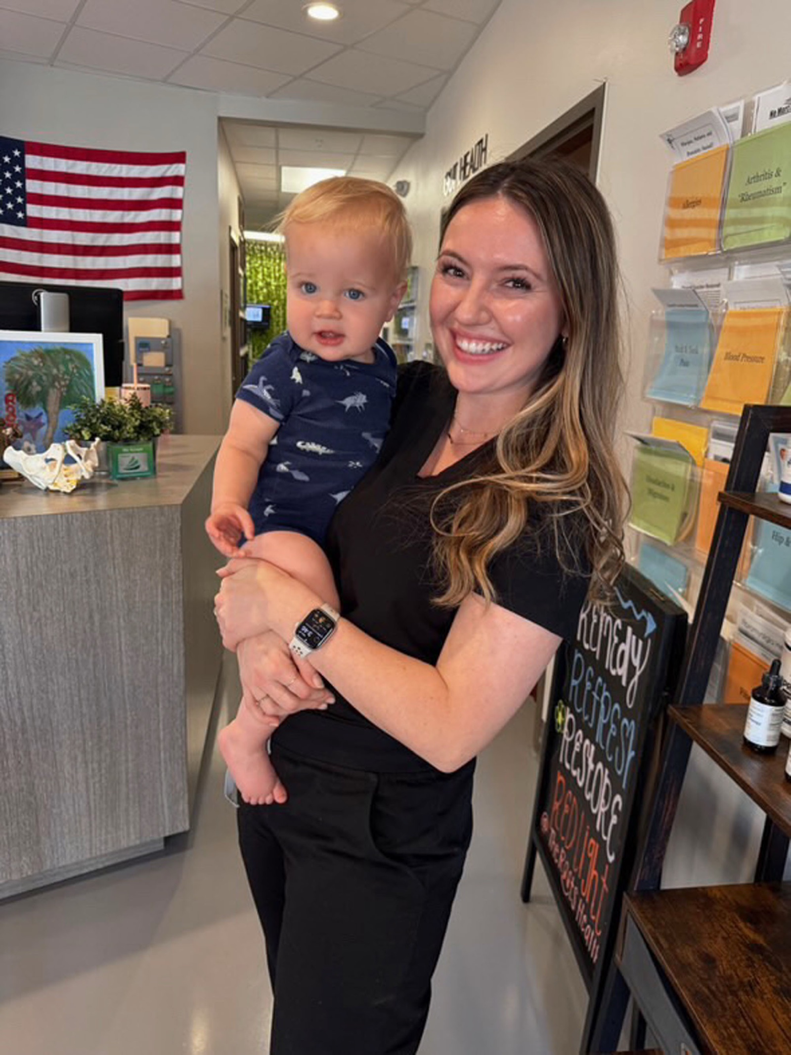 Carly holds a curious toddler at The Roots reception lobby.