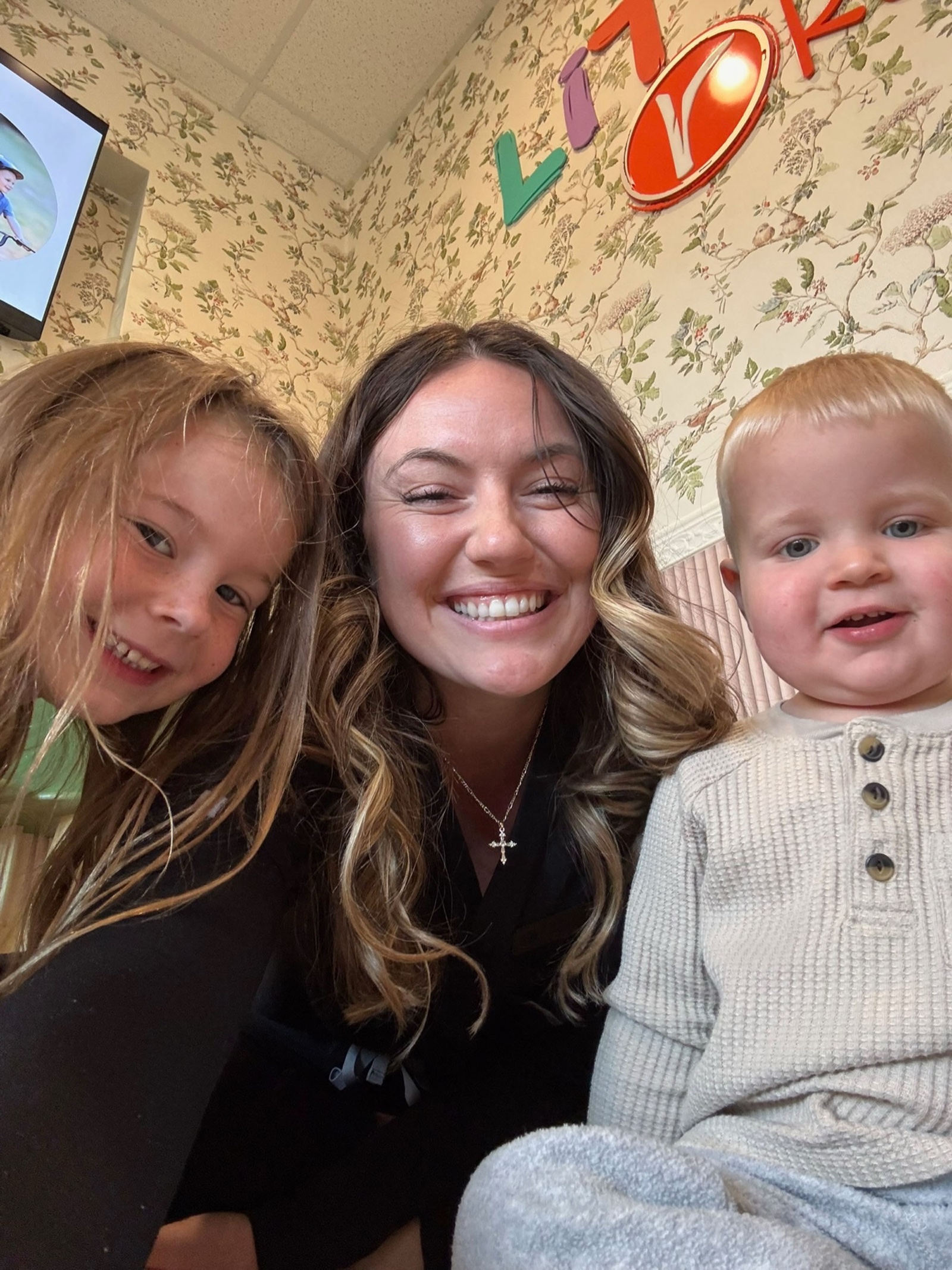 Carly poses with two young siblings in the lobby.