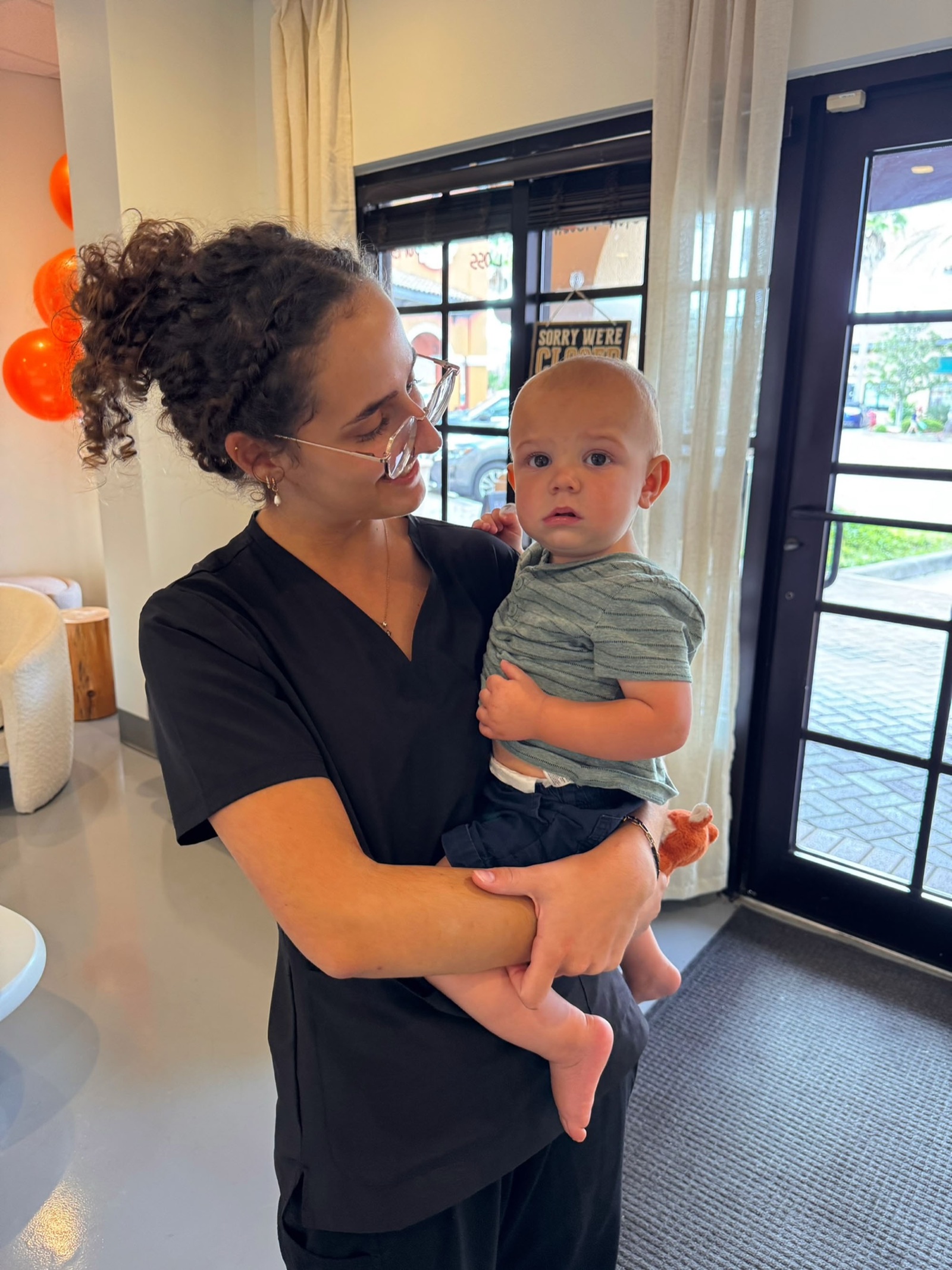 Yohanna Miller holds a small child at the clinic entrance.